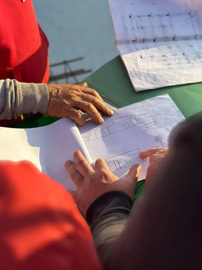 two construction workers looking at a building information model